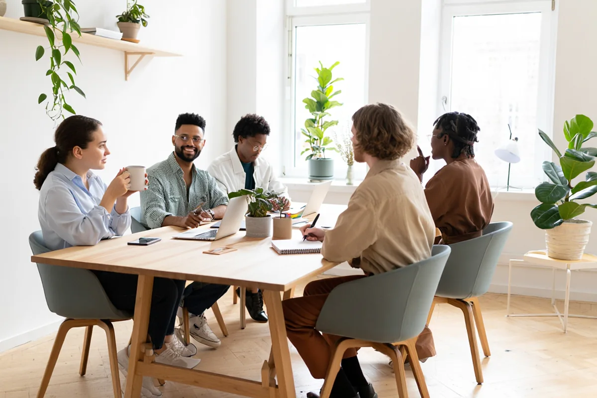 Groupe professionnel échangeant autour d’une table de réunion